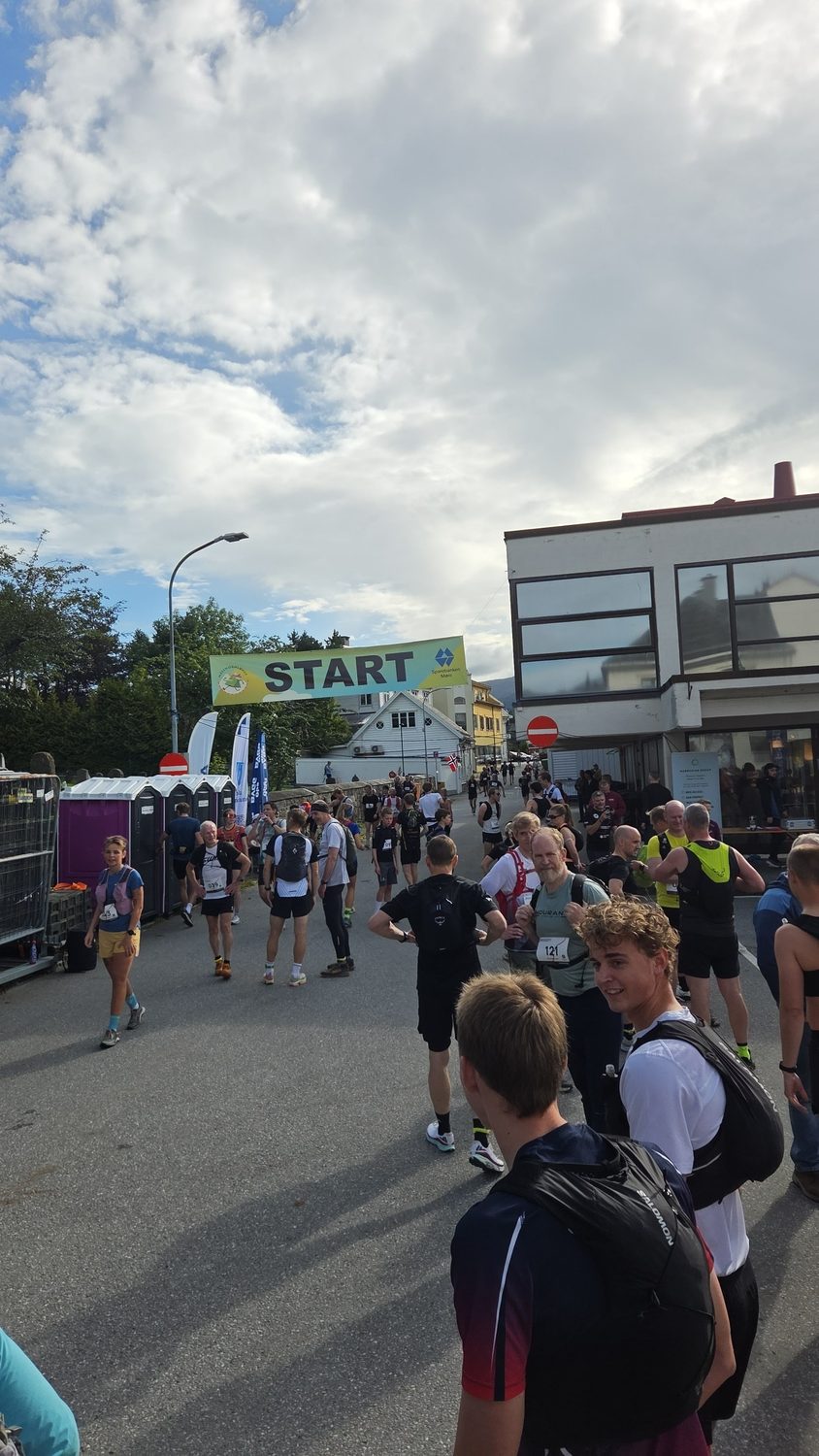 Startområdet i Volda sentrum med startbanner og løpere som varmer opp.